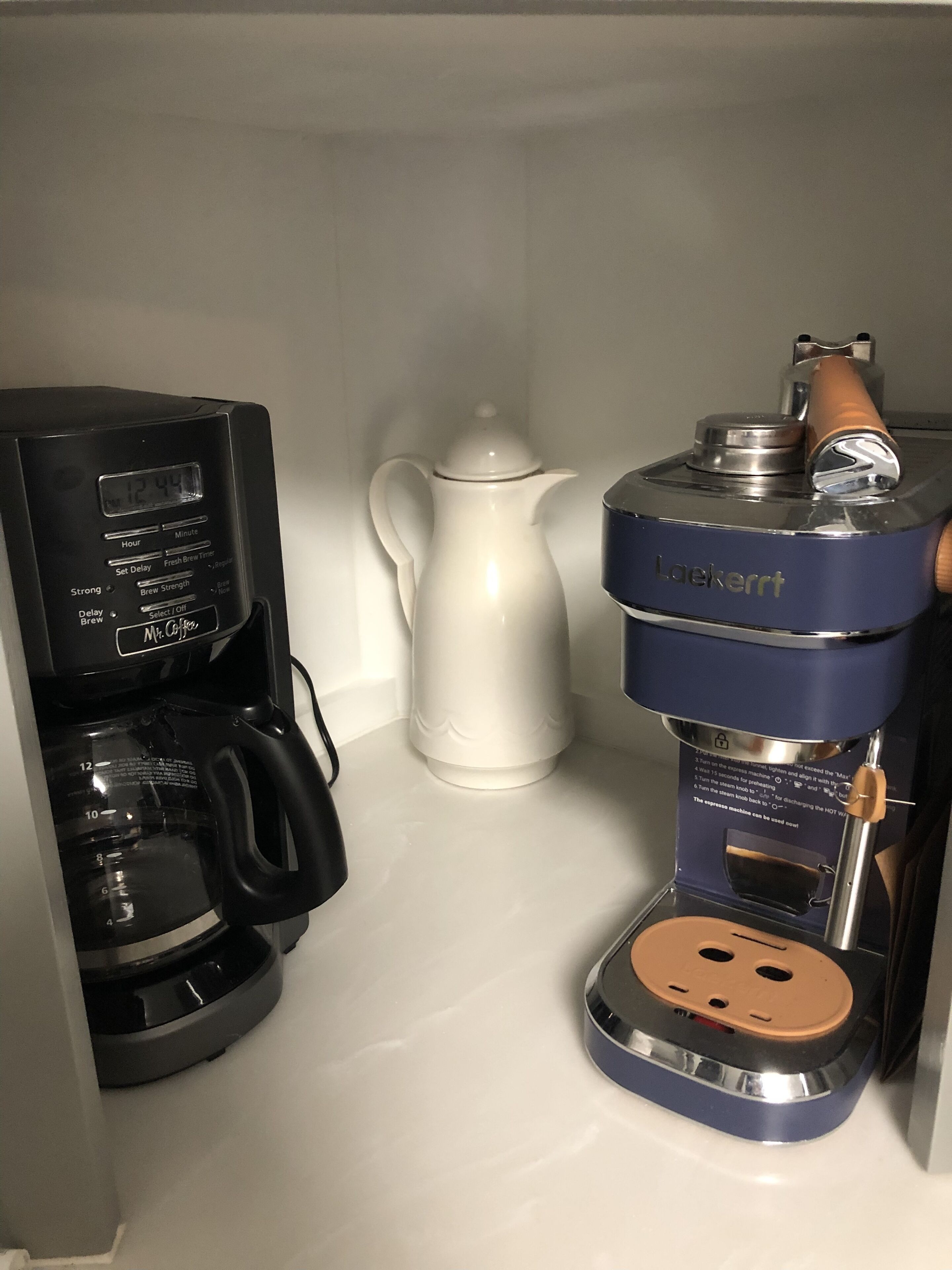 A coffee maker with a digital display and a manual coffee pot.