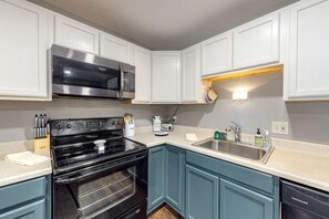 Enjoy cooking in this fully equipped kitchen with a stainless steel range hood, microwave, and dishwasher.