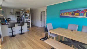 A modern kitchen with a dining area. - Sun trap with ocean views (Mangawhai Heads)