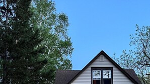 Une maison à deux étages avec une porte d’entrée, un garage et un chemin menant à l’entrée.
