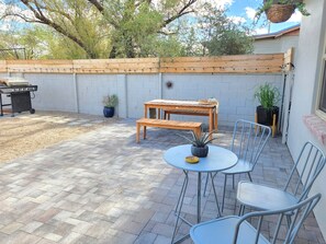 A patio with a wooden table and chairs, a barbecue grill, and potted plants. - ZonaMod MidCentury ⁜King ⁜FirePit ⁜Backyard ⁜Dog Friendly ⁜Near Downtown (Tucson)