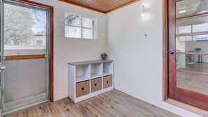 A corner room with a wooden ceiling, a white wall with a window, and a built-in white shelf with storage boxes. - ZonaMod MidCentury ⁜King ⁜FirePit ⁜Backyard ⁜Dog Friendly ⁜Near Downtown (Tucson)