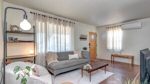 A modern living room with a sofa, coffee table, and decorative plants. - ZonaMod MidCentury ⁜King ⁜FirePit ⁜Backyard ⁜Dog Friendly ⁜Near Downtown (Tucson)