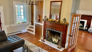 A living room with a fireplace, a sofa, and a staircase.