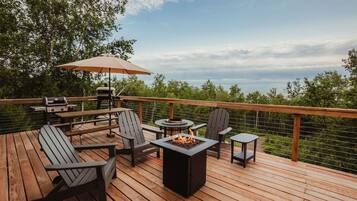 A deck with outdoor furniture, a grill, and a fire pit.