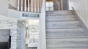 A staircase with a white balustrade leading to a second floor. A sign above the staircase reads "Cabanas."