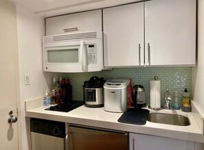 A compact kitchen with a microwave, toaster, and coffee maker. - Best studio in the heart of West Village! (New York)