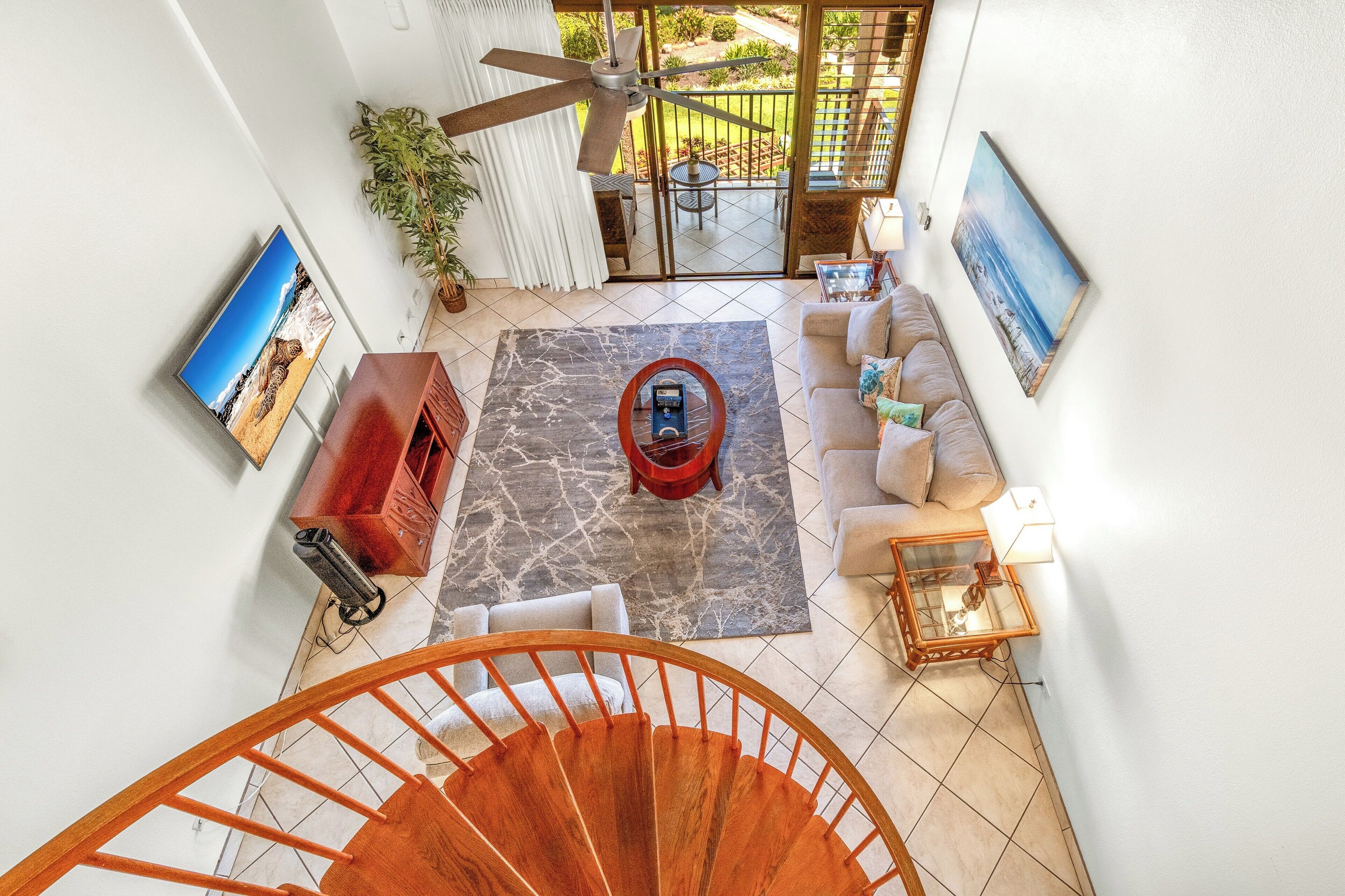 A spacious living area with a sofa, coffee table, and a view of the outdoors through a sliding glass door.
