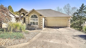 A single-story house with a garage, a driveway, and a landscaped front yard. - Bella Views! Biking/Walking Trail System Hub! (Bella Vista)