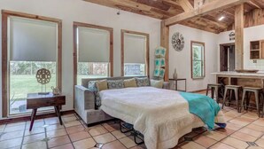 Un dormitorio con una cama grande, un escritorio y un comedor.
