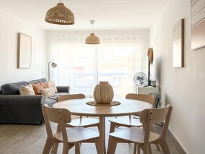 Ein Essbereich mit einem runden Tisch, vier Stühlen und zwei Pendelleuchten.