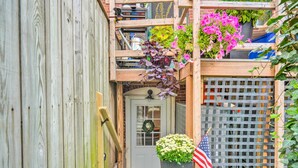 A wooden house with a gray door, a small porch, and a lattice window. - 2 Mi to Dtwn: Boston Apartment Near Beaches! (Boston)