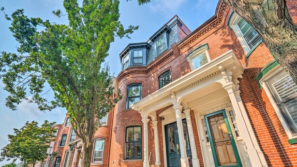 A row of red brick townhouses with white trim, green shutters, and a central entrance with columns. - 2 Mi to Dtwn: Boston Apartment Near Beaches! (Boston)