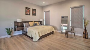 A bedroom with a bed, nightstands, a ceiling fan, and a large window with blinds. - Sedona Sanctuary w/ Hot Tub, Fire Pit & Grill (Sedona)