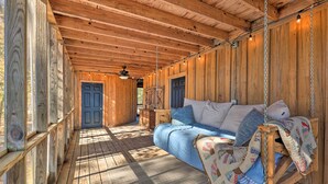 Ein Holzblockhaus mit Hängesitz, Holzböden und rustikaler Decke.