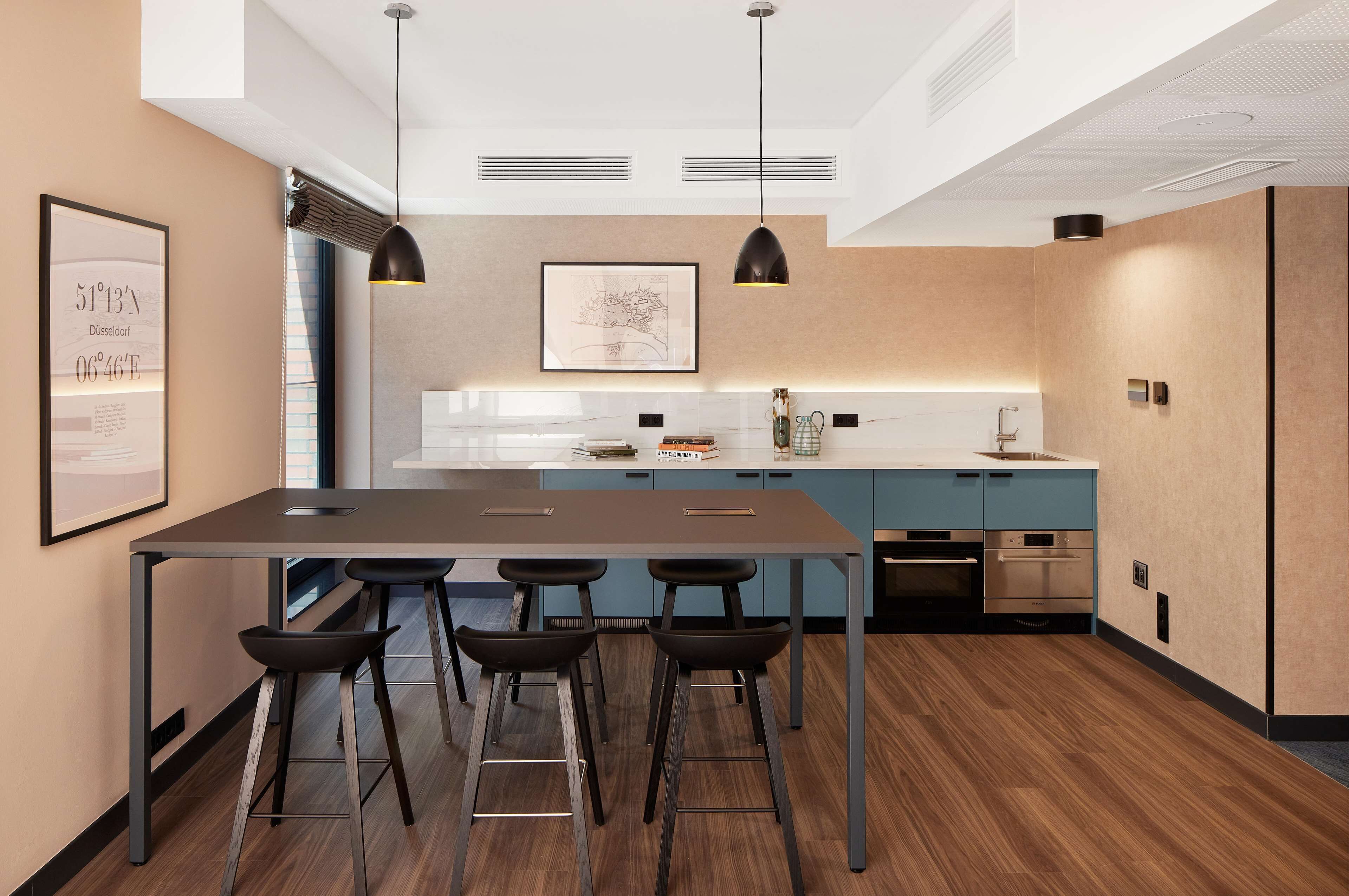 A modern kitchen with a central island, bar stools, and built-in appliances.