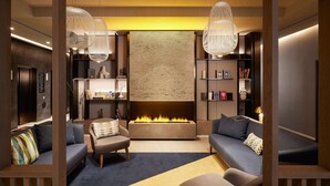 A modern living room with a fireplace, sofas, and a bookshelf.
