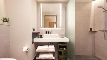 A modern bathroom with a white sink, a mirror, a towel rack, and a shower.