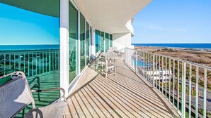 Un balcon avec vue sur l’océan, une piscine et une plage.
