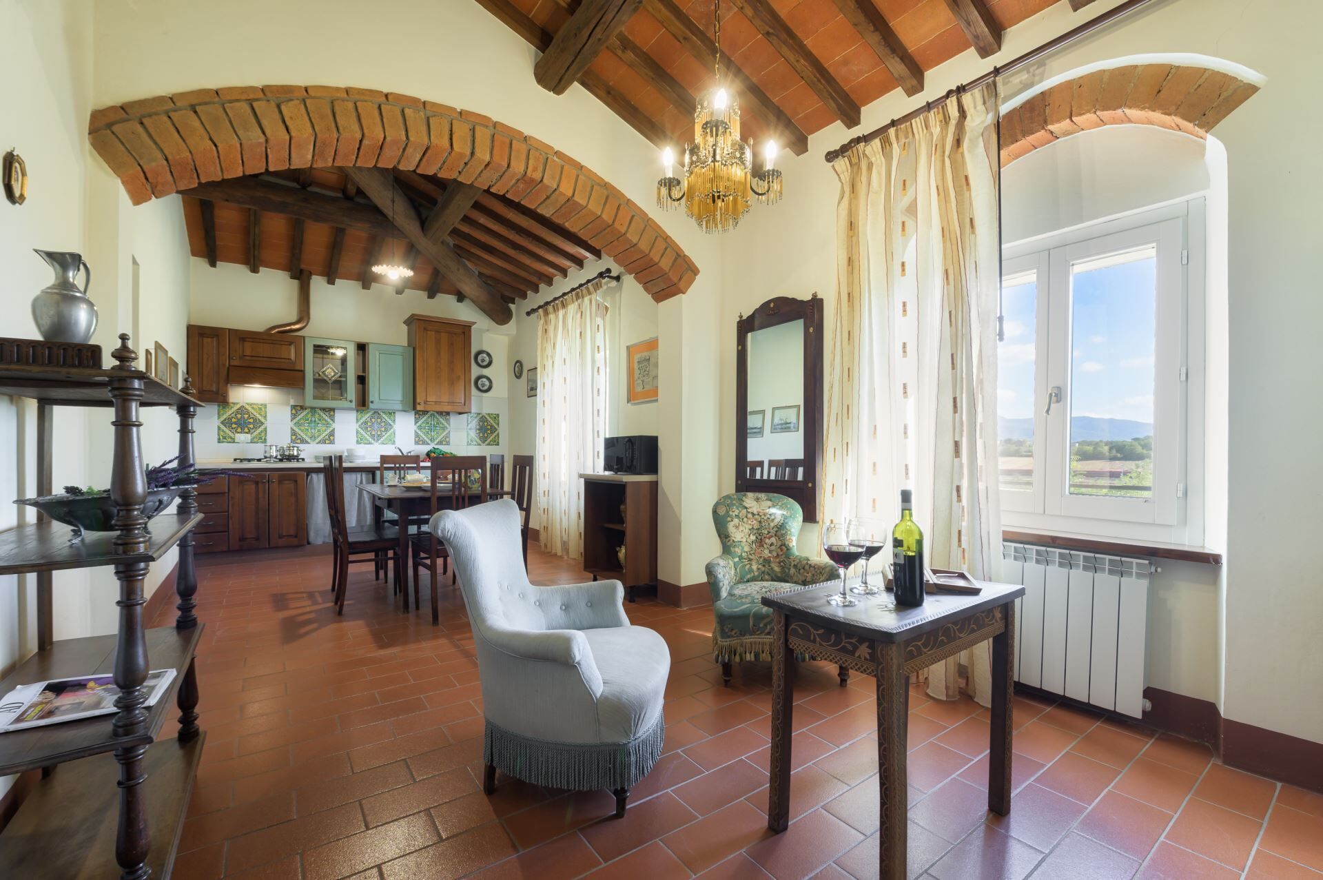 Un amplio salón con una mesa de comedor, un sillón cómodo y vistas al exterior a través de un ventanal.