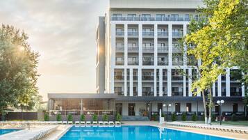 Enjoy a refreshing swim in our pool surrounded by comfortable lounge chairs and lush greenery.