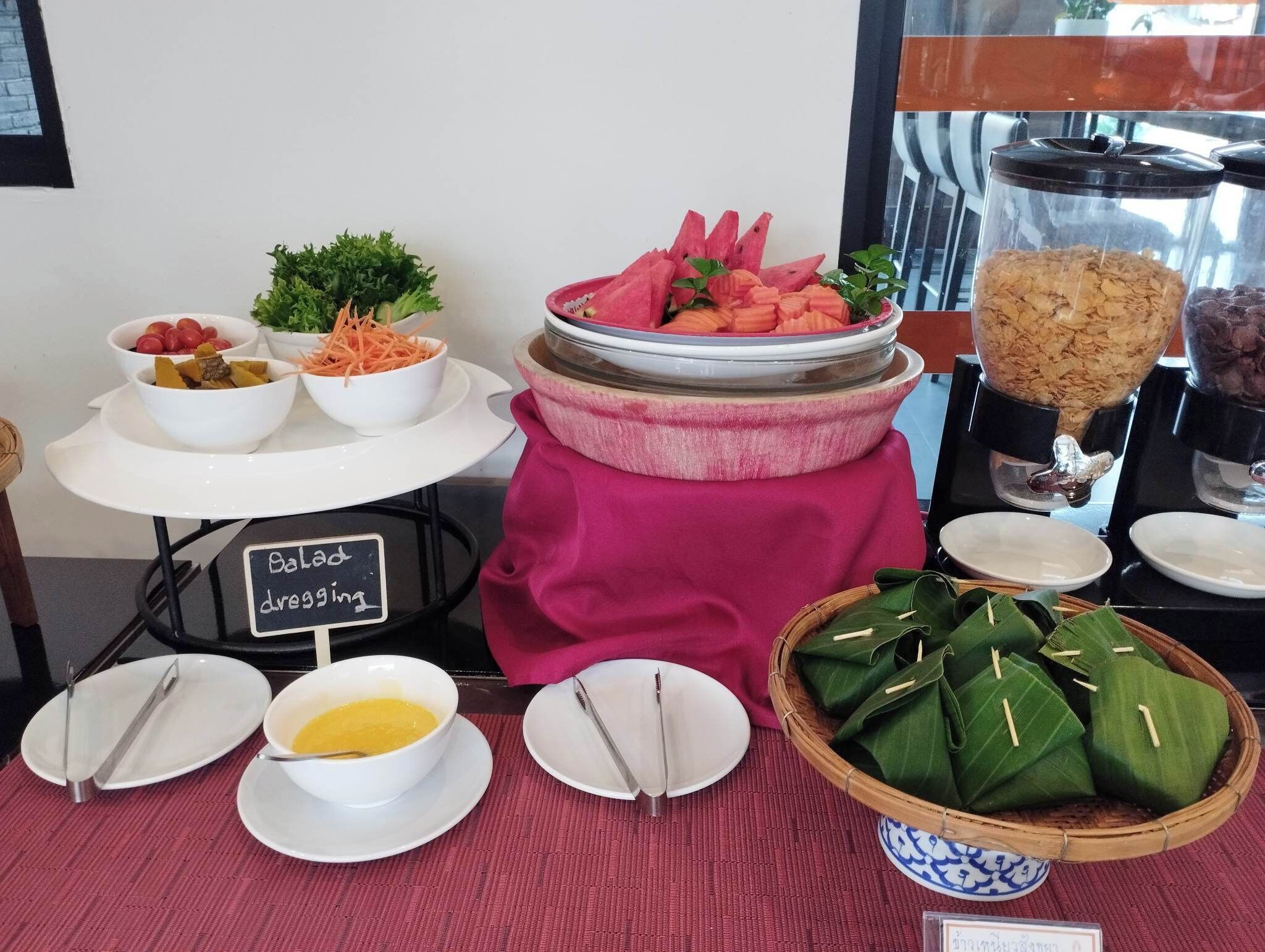A buffet setup with various food items, including bowls of salad, vegetables, and a sign indicating 'Balanced diet'.