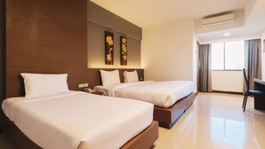 A hotel room with two beds, a desk, and a large window with curtains. - B2 Chang Phueak Gate Premier Hotel (Chiang Mai)