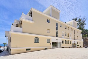 Un hôtel à plusieurs étages, doté d’une façade sobre, de grandes fenêtres et d’une entrée centrale.
