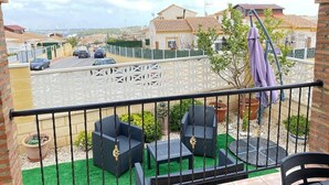 A balcony with outdoor furniture, a view of a street, and a white lattice fence. - Bungalow "Alberca La Nucia" with Mountain view, Terrace & Wi-Fi (polop)