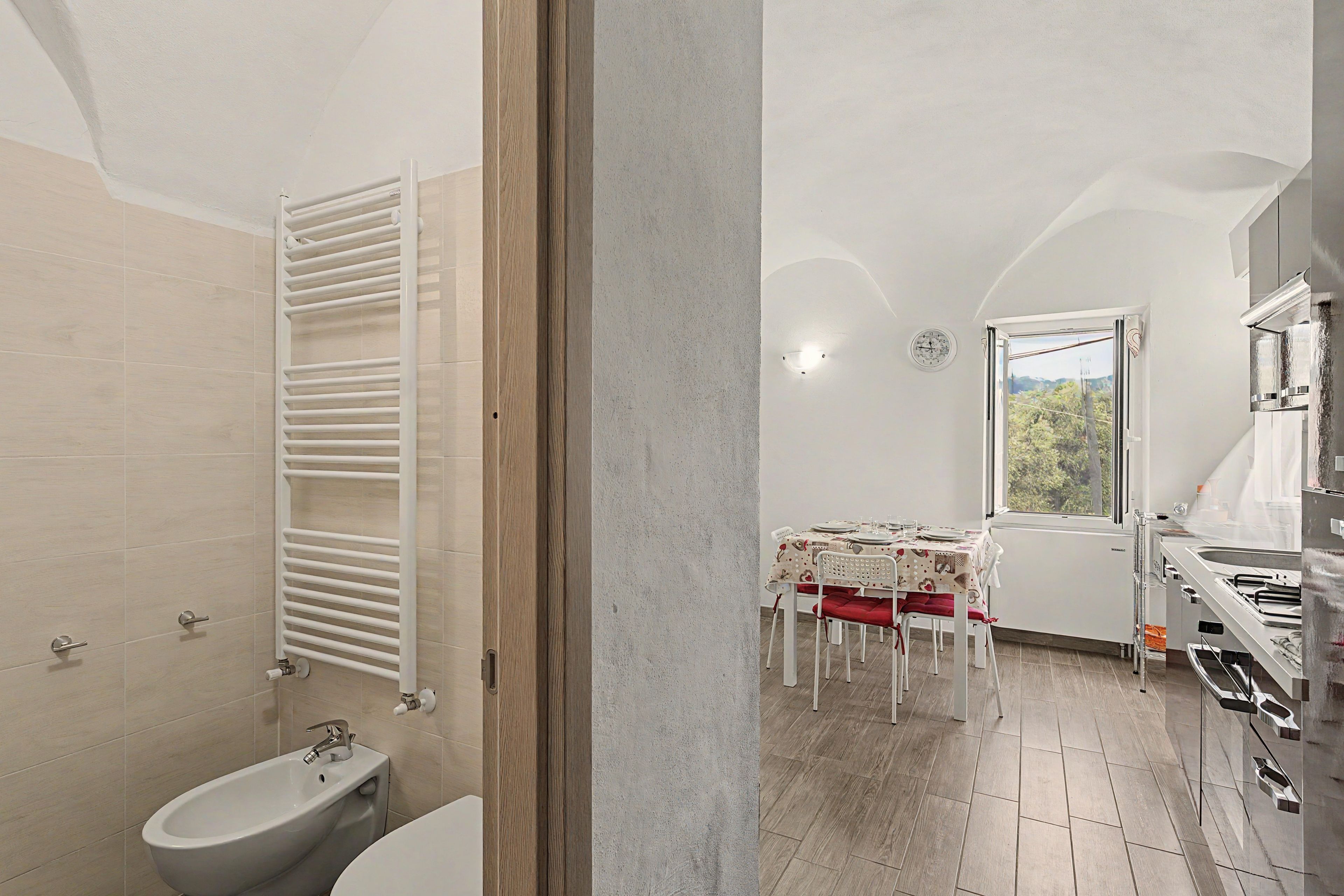 A bathroom with a white bathtub, a white toilet, and a white towel rack.