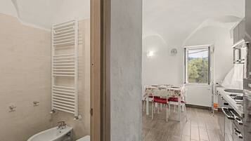 A bathroom with a white bathtub, a white toilet, and a white towel rack.