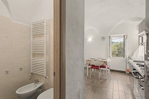 A bathroom with a white bathtub, a white toilet, and a white towel rack.