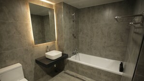 A modern bathroom with a toilet, sink, and bathtub. - Hotel Seven Step (Siheung)