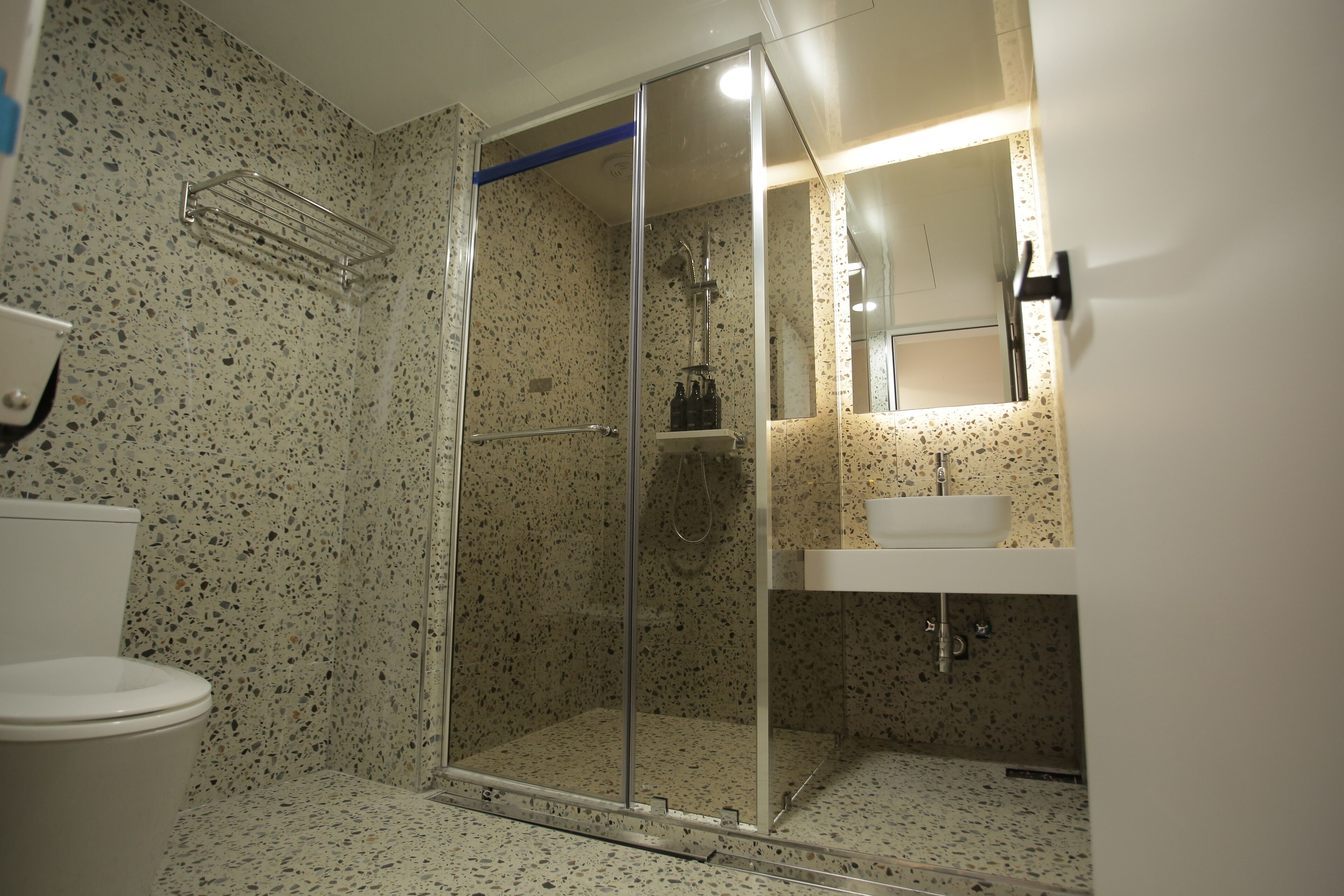 A bathroom with a shower, toilet, and sink.