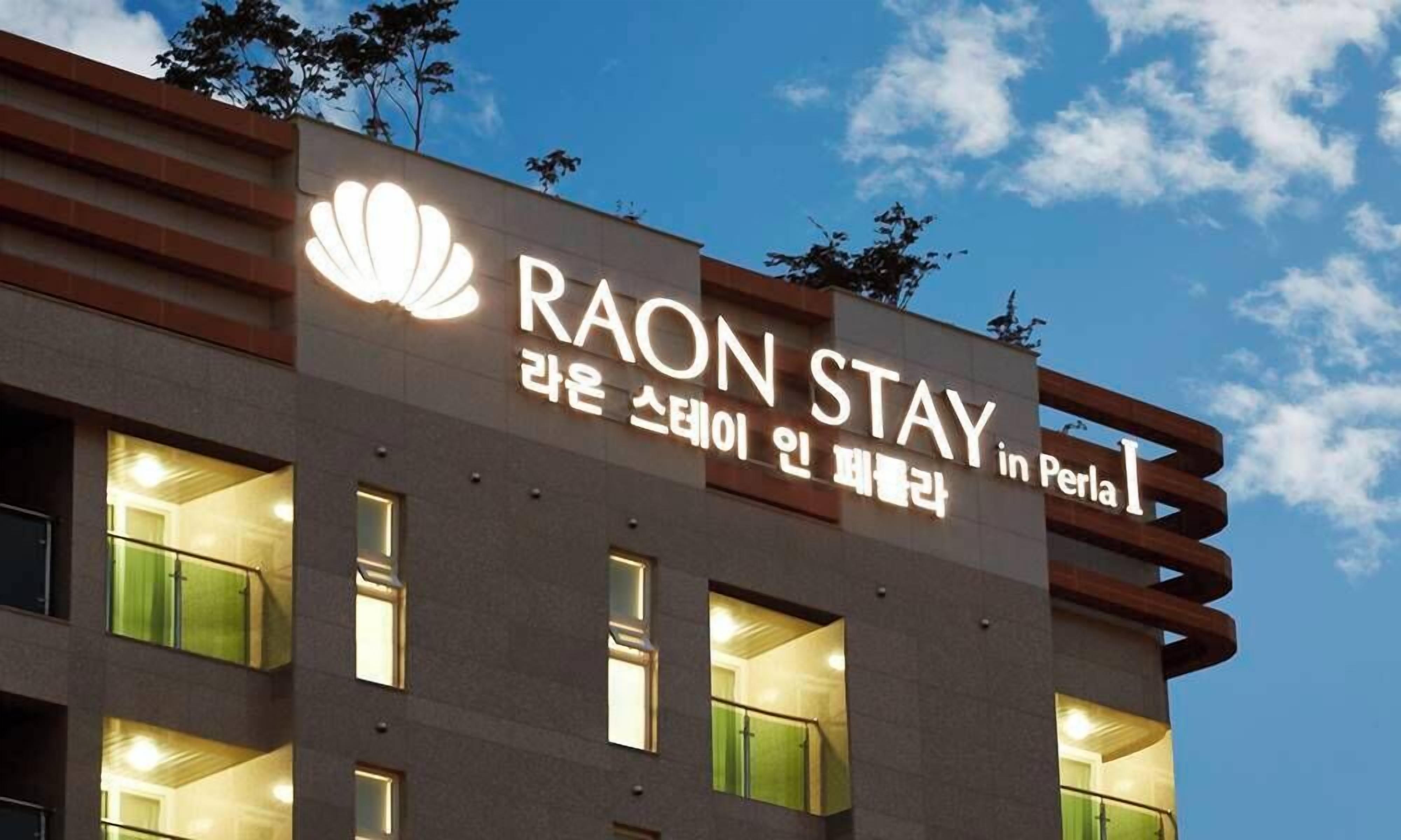 A hotel sign with the name 'RAON STAY' and 'in Perla' indicating its location.