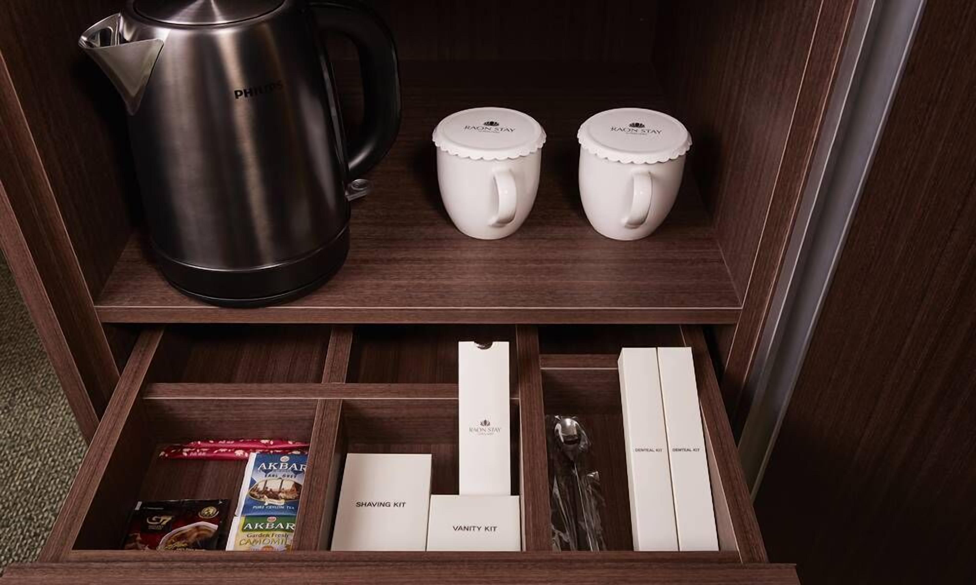 Un tiroir contenant un nécessaire de rasage, une trousse de toilette et une machine à café.