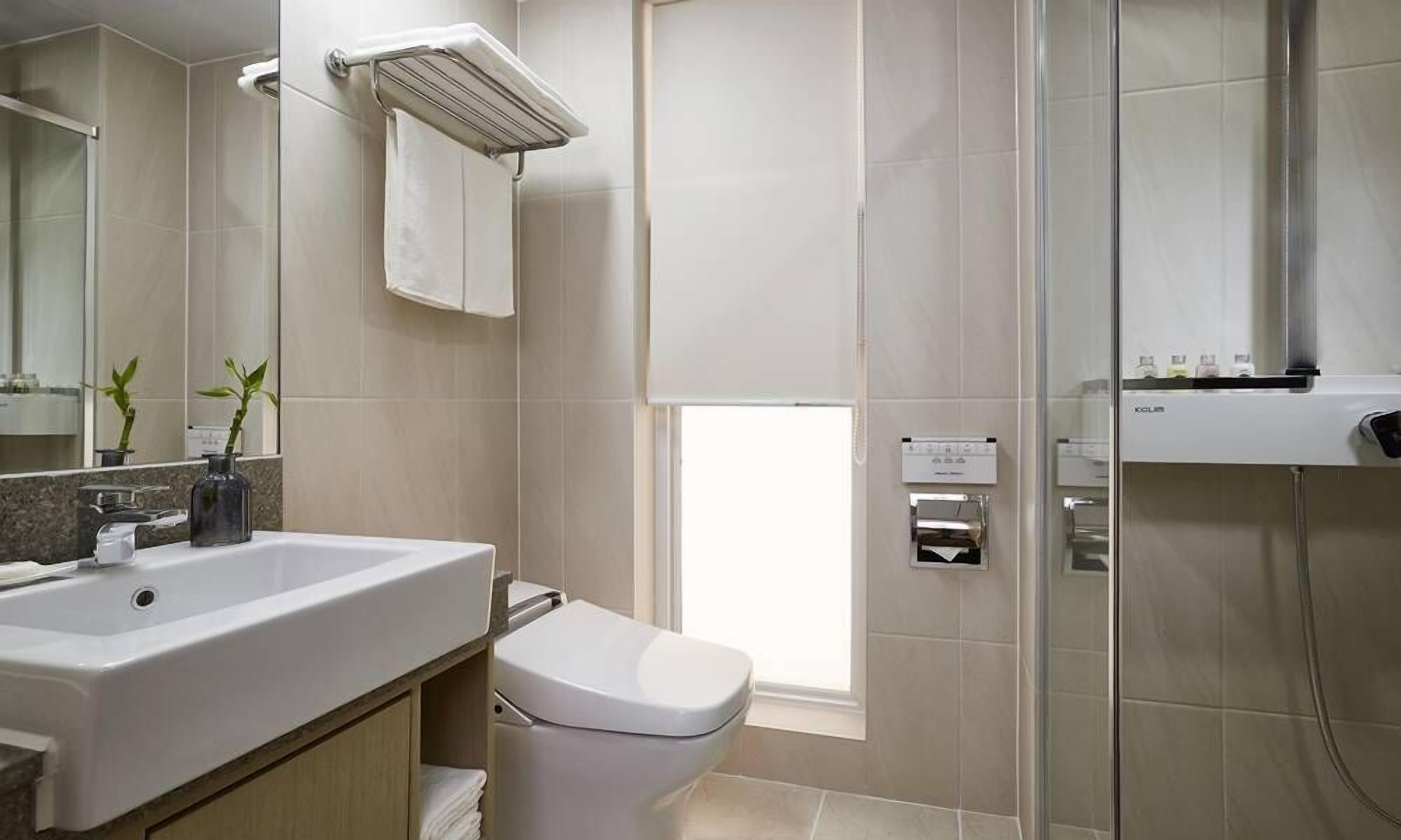 Un baño moderno con un lavamanos grande, inodoro y zona de ducha.