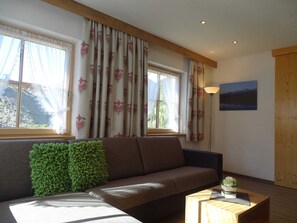 Een woonkamer met een bank, een houten salontafel en een lamp.