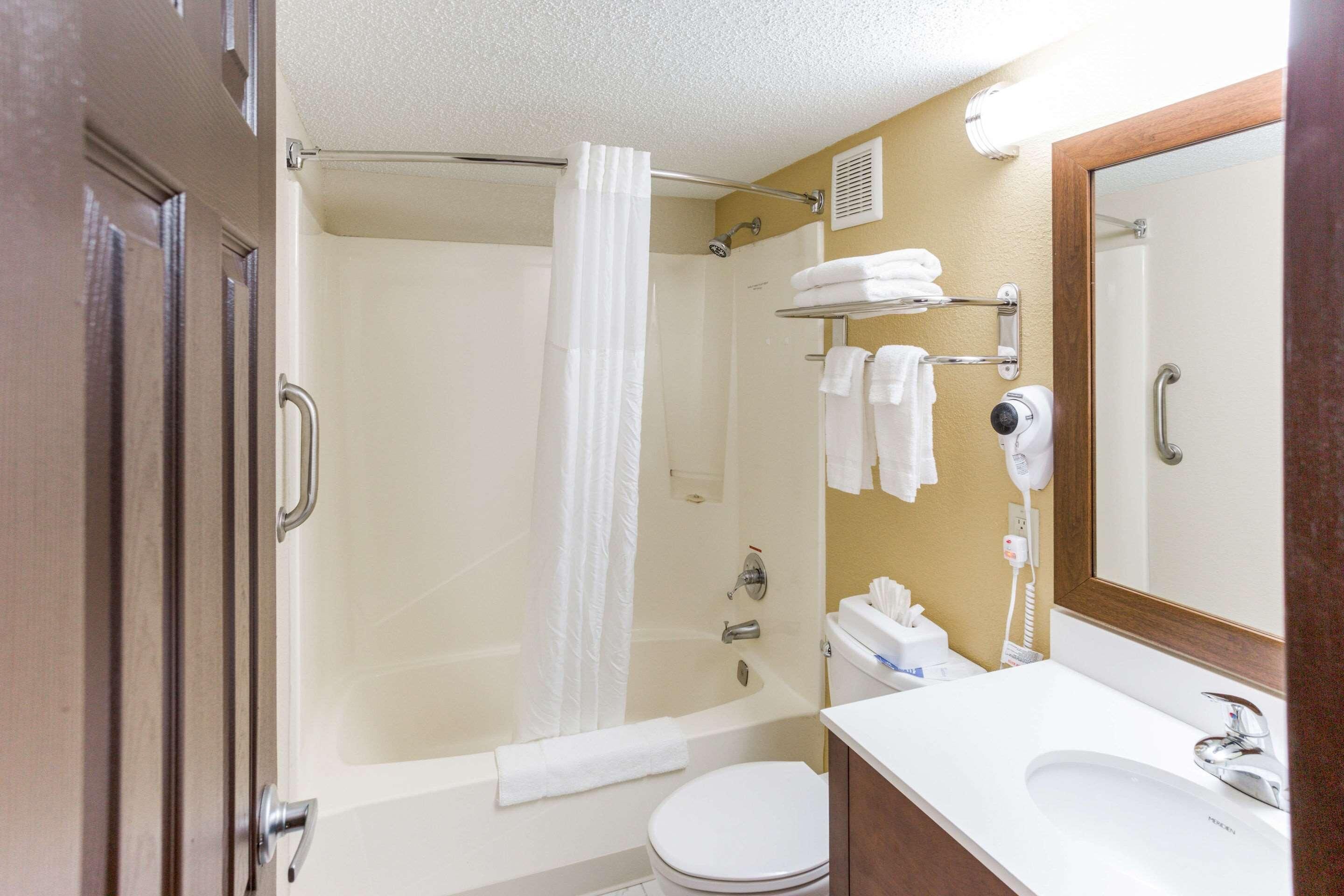 A bathroom with a bathtub, toilet, and sink.