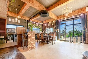A spacious dining area with a wooden ceiling and large windows. - Seogwipo Unyeong Pension (Seogwipo)