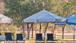 A pool area with lounge chairs and umbrellas.