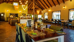 A restaurant with a wooden ceiling and tables set for dining.