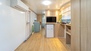 A compact kitchen with wooden cabinets, a refrigerator, and a microwave. - Pocheon Kidsglampinggeo (Pocheon)