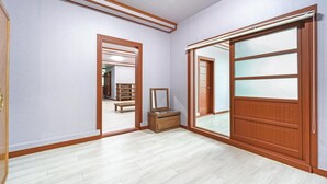 A hallway with wooden flooring, a mirror, and a bench. - Ganghwa Dondaemoru Pension (Incheon)