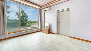 A room with large windows, a door, and a small wooden cabinet. - Ganghwa Dondaemoru Pension (Incheon)