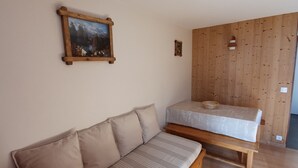 Una habitación con pared de madera, un banco de madera, un sofá y un cuadro en la pared.