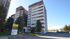 Un edificio de varios pisos con un diseño moderno, que combina colores blanco y marrón.