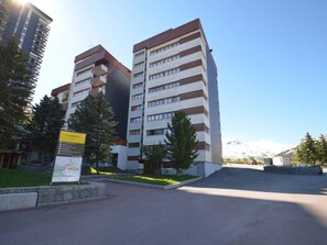 A multi-story building with a modern design, featuring a mix of white and brown colors.