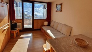 Una habitación acogedora con sofá, una mesita y televisor.