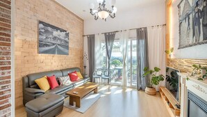 A living room with a brick wall, a sofa, a coffee table, and a fireplace. - Jeju Jongdalrifeel House (Jeju City)